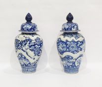 Pair of Asian porcelain blue and white oviform vases and domed covers, moulded in relief with