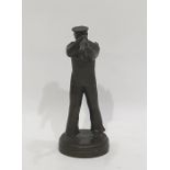 A bronze sculpture of a sailor looking through a telescope, in the Art Deco Style on a circular