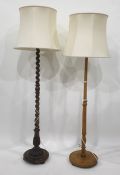 Two oak standard lamps with cream shades