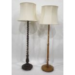 Two oak standard lamps with cream shades