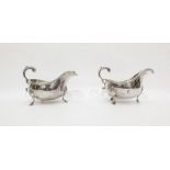 Pair of Victorian silver gravy boats with foliate scroll handles, gadrooned borders, raised on pad