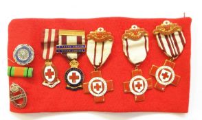 Collection of five British Red Cross nursing medals and badges, commemorative coins.