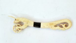 Carved bone and horn pastry jigger with unicorn above the wheel and fish tail handle, 19cm long