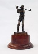 A bronze effect figure of golfer on stained wood plinth base