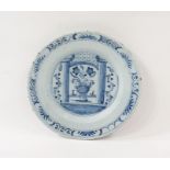 Antique Delft plate painted in underglaze blue with vase of flowers between pillars and brick