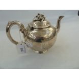 Late Victorian silver bachelor's bullet shaped teapot, the hinged cover with foliate surmount,