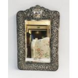 Edwardian silver toilet mirror, rectangular with shaped top, vacant cartouche, all over floral and