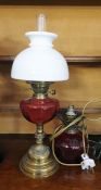 Oil lamp with cranberry glass-coloured well, on a stepped brass base, with a white opaque glass