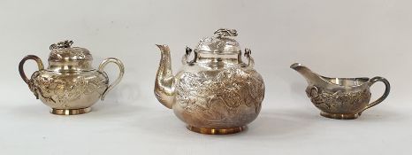 Chinese sterling white metal three-piece tea service, viz:- teapot with swing handle, dragon's