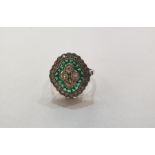 Victorian style, platinum, emerald and diamond ring set four diamonds to the centre surrounded by