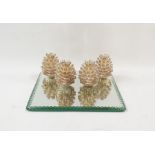 Square mirrored base with four fir cone candleholders