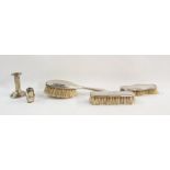 Three assorted silver-backed dressing table brushes, weighted silver candlestick and a weighted