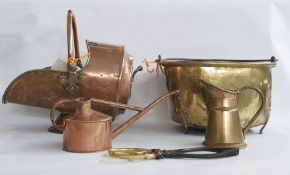 Large brass coal bucket with swing metal handle, on three supporting feet and a helmet copper coal