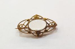 Gold coloured metal and moonstone Arts and Crafts style brooch, the oval stone surrounded by trefoil