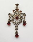 Edwardian-style, garnet, seedpearl and diamond pendant of scroll design, set with central garnet,