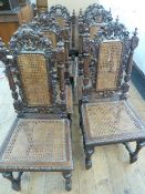Set of six Carolean style oak dining chairs, each carved with fruiting vine, with caned back and
