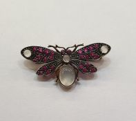 Silver coloured metal and gilt, ruby and moonstone butterfly brooch having four cabochon