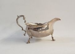 Silver sauceboat with cut card borders, scroll handle, raised on cabriole legs with pad feet,