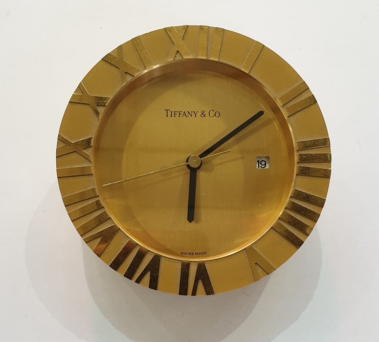 Tiffany gilt metal Atlas desk clock, circular with quartz movement, calendar aperture and Roman