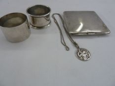 Two silver napkin rings, silver cigarette case, engine turned, and a silver St. Christopher