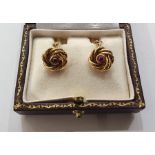 Pair gold-coloured knot, torpedo and chain cufflinks, each knot set with single cabochon ruby,