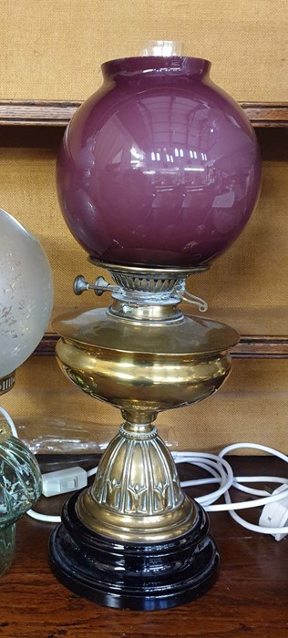 19th century oil lamp converted to electricity, with a purple bowl ovoid shade, with a brass well,