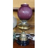 19th century oil lamp converted to electricity, with a purple bowl ovoid shade, with a brass well,