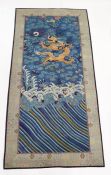 Chinese silk panel depicting a dragon in gold thread, the dragon has five claws, above a stormy