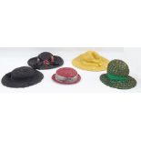 Various vintage hats including a black straw decorated with faux-flowers, a large coolie hat with