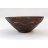 Studio pottery terracotta bowl with purple and brown glazes, whirl decoration and incised border