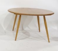 Light elm Ercol circular coffee table on beech supports, 73.5cm diameter