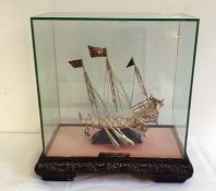 Eastern white metal model of a Dhow, on stand, in glass case