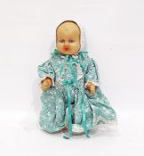 Rubber baby doll wearing green and white floral dress, pantaloons and bonnet, 31cm