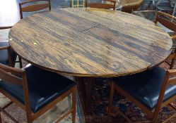 1970's Heals rosewood extending dining table of circular form, on four rectangular supports (CITES