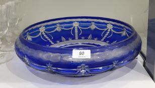 Large blue overlay cut glass bowl with incurved rim and formal swag, palmette and foliate