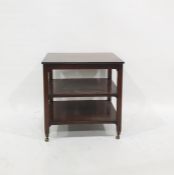 Polished hardwood three-tier occasional table, on brass castors, 61cm wide