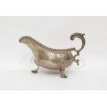 George V silver sauce boat with acanthus decorated handle, gadrooned rim, on three shell decorated