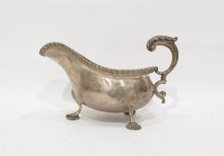 George V silver sauce boat with acanthus decorated handle, gadrooned rim, on three shell decorated