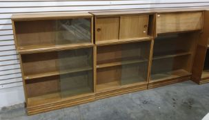 Light oak modular lounge suite comprising a corner unit, assorted glass-fronted shelving units, a