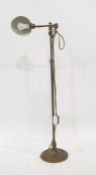 Brass spot lamp on floor-standing telescopic frame