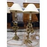Pair of brass table lamps, each decorated with three flowerheads and leaves on a foliate tripod