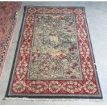 Modern rug, the central field with wooded landscape scene, red ground foliate decorated border