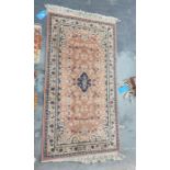 Modern peach ground rug with central medallion foliate decorated field and stepped border, 156cm x