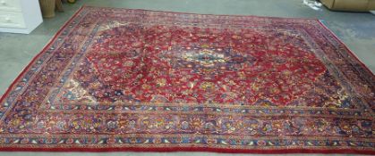 Red ground rug with stepped central foliate decorated medallion, the field with allover foliate