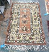 Peach ground rug with four diamond-shaped central medallions, on a stepped border, 175cm x 122cm