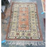 Peach ground rug with four diamond-shaped central medallions, on a stepped border, 175cm x 122cm