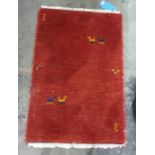 Modern red ground rug decorated with animals, 89.5cm x 61cm