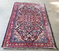 Black ground rug with foliate central red ground medallion, foliate decorated border, cream ground