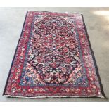 Black ground rug with foliate central red ground medallion, foliate decorated border, cream ground