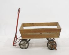 A child's push cart with metal handle, on four wheels